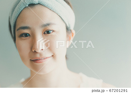 ヘアバンドをして洗顔をする30代女性 67201291
