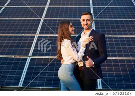 Beautiful couple by a solar panel Beautiful couple by a solar panel 67203137