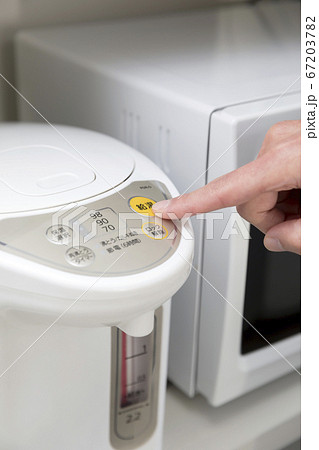 電気ポットの給湯ボタンを押す女性手元 67203782