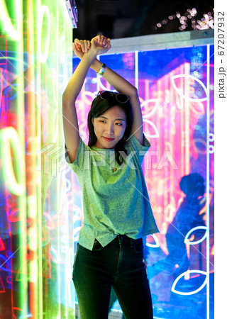 Asian woman portrait lit up by neon lights at Asian woman portrait lit up by neon lights at 67207932