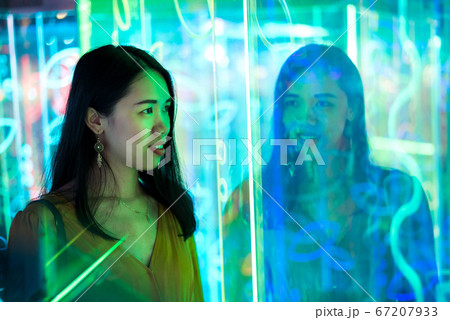 Asian woman portrait lit up by neon lights at 67207933