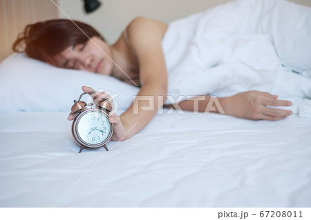 alarm clock and asian woman hand stop time in bed alarm clock and asian woman hand stop time in bed 67208011