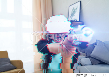 Woman with virtual reality headset is playing game. Image with glitch effect. 67208076