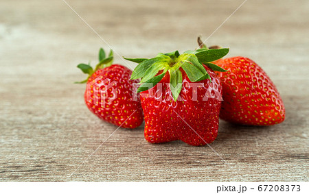 fresh strawberries on a wooden background. bright and juicy berries. source of useful substances and vitamins. fresh strawberries on a wooden background. bright and juicy berries. source of useful substances and vitamins. 67208373