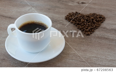 making coffee. Cup of fragrant coffee. beans are laid out in the shape of a heart. making coffee. Cup of fragrant coffee. beans are laid out in the shape of a heart. 67208563