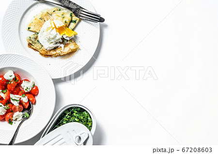 Thin pancakes with greens and poached egg. White background. Top view. Copy space Thin pancakes with greens and poached egg. White background. Top view. Copy space 67208603