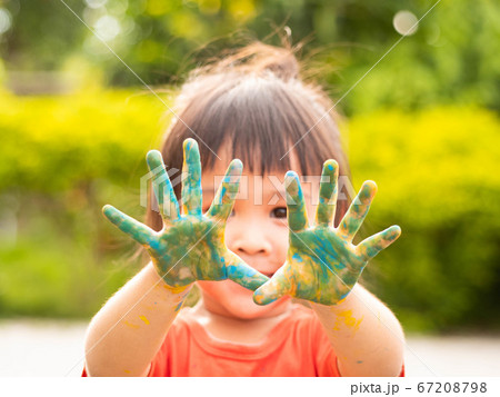 Cheerful little child girl with hands painted in 67208798