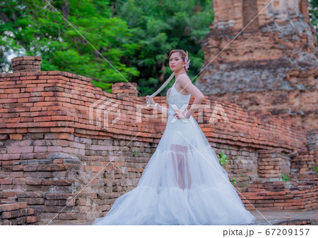 Woman wearing typical thai dress with thai style, Beauty fantasy Thai dress traditional costume on brick in old temple Woman wearing typical thai dress with thai style, Beauty fantasy Thai dress traditional costume on brick in old temple 67209157