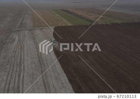 Tractor plows a field, aerial view.  67210113