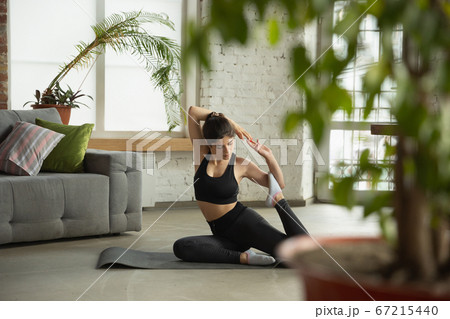 Sporty young muslim woman taking yoga lessons online and practice at home 67215440