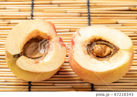 傷み桃 半分カット 半分に切った桃の断面。背景、すだれ。の写真素材 [67216343] - PIXTA