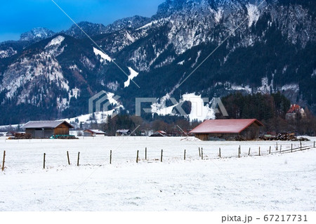 Wooden shed in snowy field against Alps in winter Wooden shed in snowy field against Alps in winter 67217731