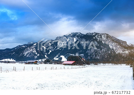 Wooden shed in snowy field against Alps in winter Wooden shed in snowy field against Alps in winter 67217732