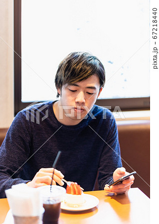 カフェでケーキを食べる若い男性 67218440