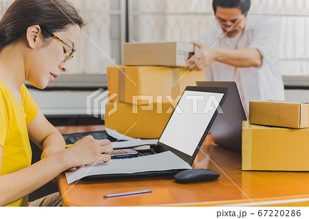 Business couple hand writing address on parcel box work from home. 67220286