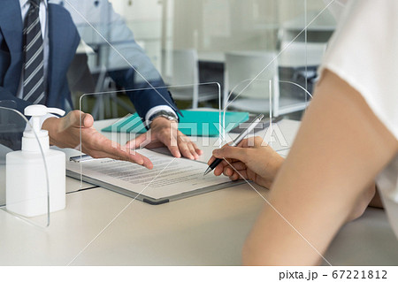 アクリルパーティション越しに話すビジネスマン　感染対策　ソーシャルディスタンス 67221812