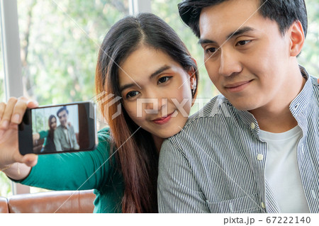 Happy Asian couple enjoy taking selfie photo Happy Asian couple enjoy taking selfie photo 67222140
