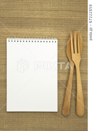 木のテーブルに置いたスケッチブックとフォークとスプーン 67222859