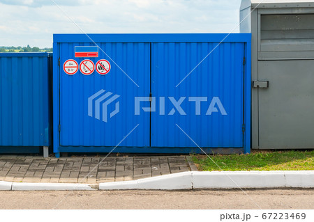 Fenced blue garbage container with fire signs Fenced blue garbage container with fire signs 67223469
