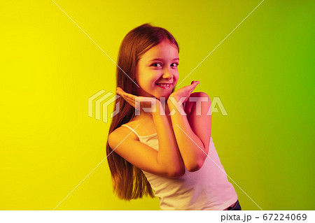 Little caucasian girl's portrait isolated on gradient background in neon light. Concept of human emotions, facial expression, modern gadgets and technologies. Copyspace. 67224069