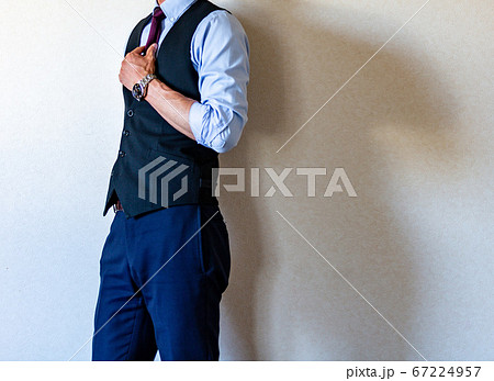 シャツを腕まくりして立っているスーツを着た男性の写真素材