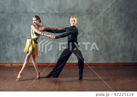 Young couple sport dancers dancing in ballroom dance cha-cha-cha. Young couple sport dancers dancing in ballroom dance cha-cha-cha. 67225119