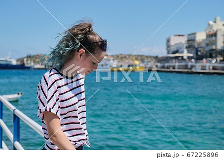 Traveling teenager girl on sea bay enjoys beauty nature, summer holidays on sea voyage 67225896