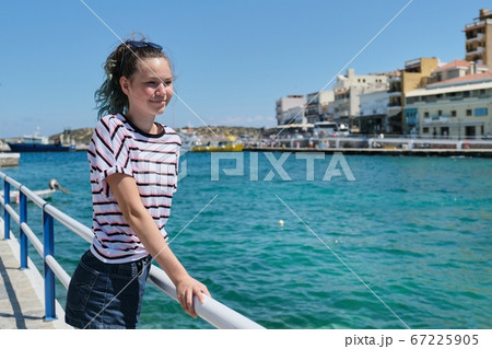 Traveling teenager girl on sea bay Mirabello enjoys beauty nature Traveling teenager girl on sea bay Mirabello enjoys beauty nature 67225905