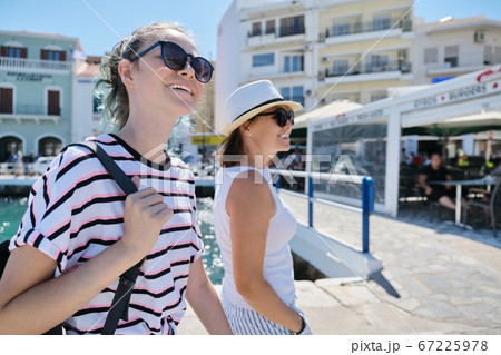 Walking happy mother parent and teenage daughter summer holidays together 67225978