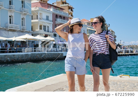Happy mother and daughter teenager walking, summer sea vacation Happy mother and daughter teenager walking, summer sea vacation 67225990