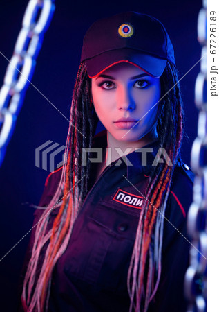 a girl in a police uniform with dreadlocks in neon light with chains and handcuffs English translation the police a girl in a police uniform with dreadlocks in neon light with chains and handcuffs English translation the police 67226189