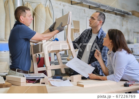 Group of working designers in carpentry workshop 67226769