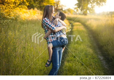 happy mom and son are playing on a summer green meadow 67226804
