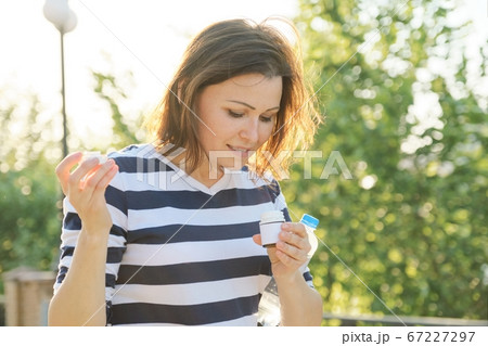 Mature woman with medication bottles of medicine, vitamins, supplements Mature woman with medication bottles of medicine, vitamins, supplements 67227297