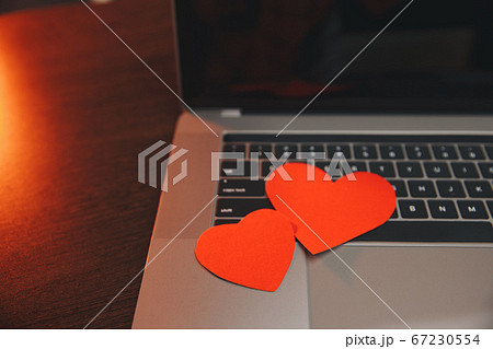 Computer with red hearts on table close up 67230554