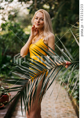 Woman in swimsuit on tropical plants background Woman in swimsuit on tropical plants background 67231233