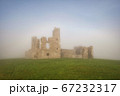 Old castle ruins in a dense fog 67232317