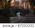 Frozen nature on the river trail and old stone bridge 67232332