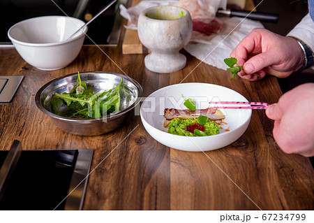 Chef decorates a peas, horse meat and kimchi sauce. Master class in the kitchen. The process of 67234799