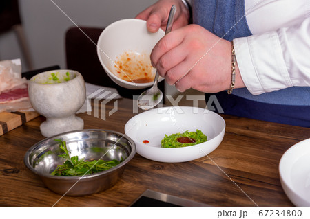 Chef decorates a peas, horse meat and kimchi sauce. Master class in the kitchen. The process of 67234800