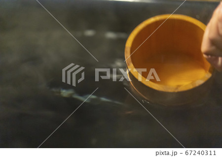 温泉の湯を風呂桶ですくう 温泉の湯を風呂桶ですくう 67240311