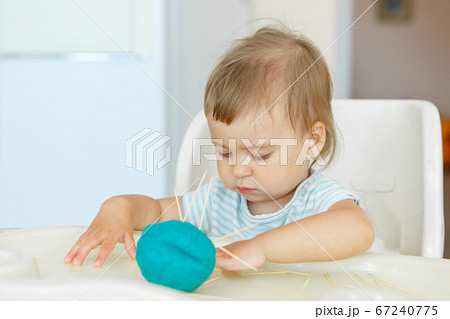 girl sculpts from plasticine. a child makes a hedgehog craft. development of fine motor skills with toothpicks 67240775