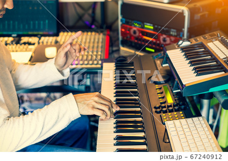 male musician, producer, composer playing electric piano in home studio male musician, producer, composer playing electric piano in home studio 67240912
