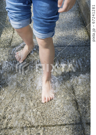 公園の水遊びスペースで水遊びをする小学生足元 67241281