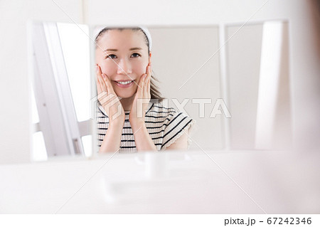 鏡をみてスキンケアをする若い女性 鏡をみてスキンケアをする若い女性 67242346
