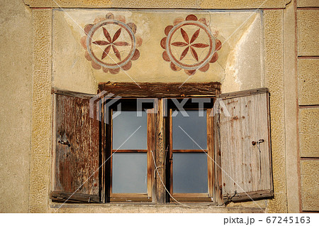 Wooden window with decorations - Guarda village Engadine Switzerland Wooden window with decorations - Guarda village Engadine Switzerland 67245163
