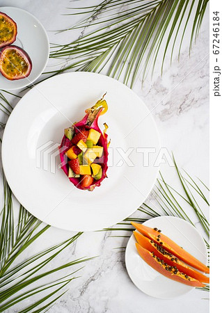 Exotic fruits and tropical leaves on table Exotic fruits and tropical leaves on table 67246184