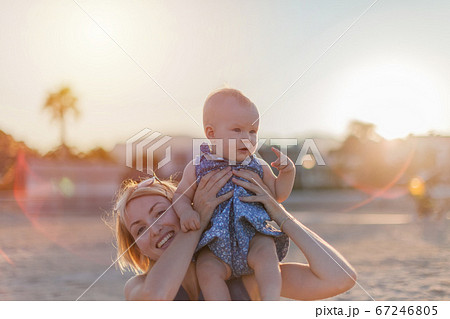 Young mother with her pretty baby girl hanging out on a summer beach 67246805