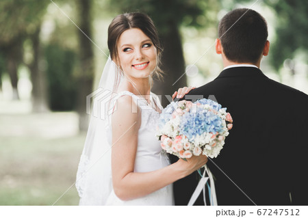 Happy wedding couple walking in a botanical park Happy wedding couple walking in a botanical park 67247512