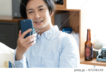 スマホでオンラインデートをする男性 67248140